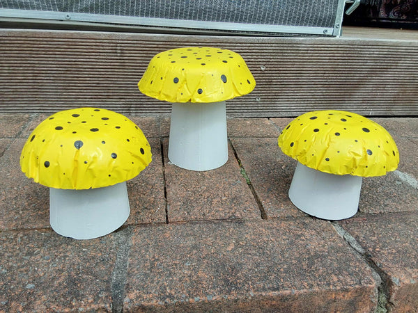 Set of 3 yellow concrete mushrooms.