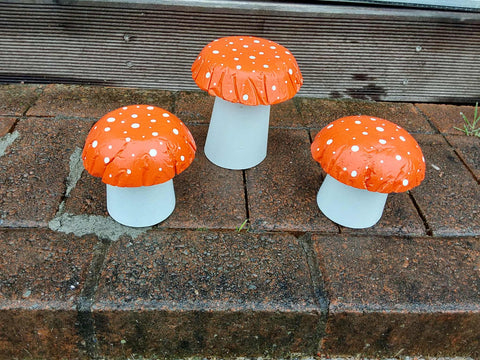 Set of 3 orange concrete mushrooms.