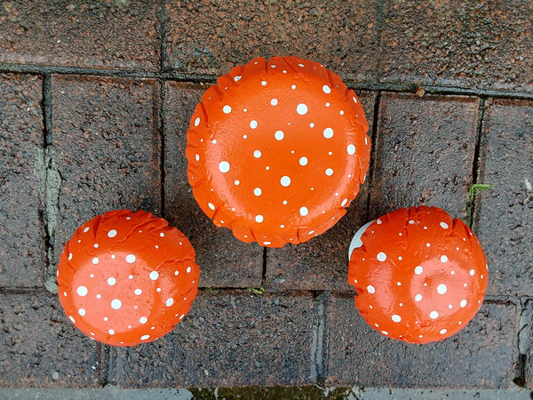 Set of 3 orange concrete mushrooms.