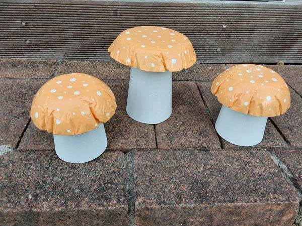 Set of 3 pastel orange concrete mushrooms.