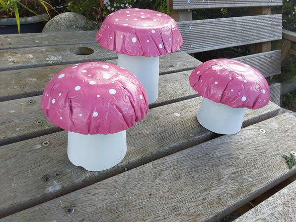 Set of 3 pink concrete mushrooms.