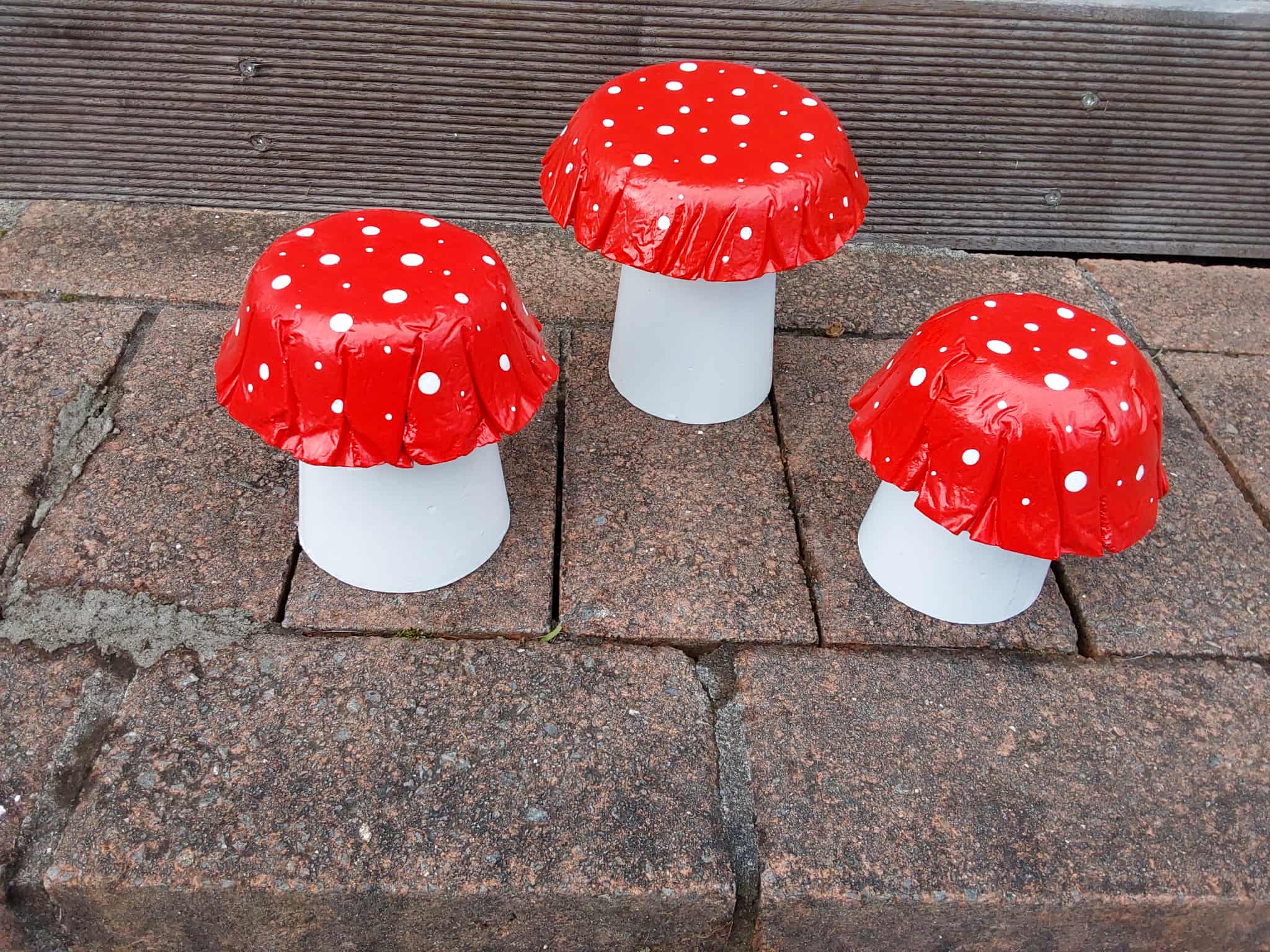 Set of 3 red concrete mushrooms.