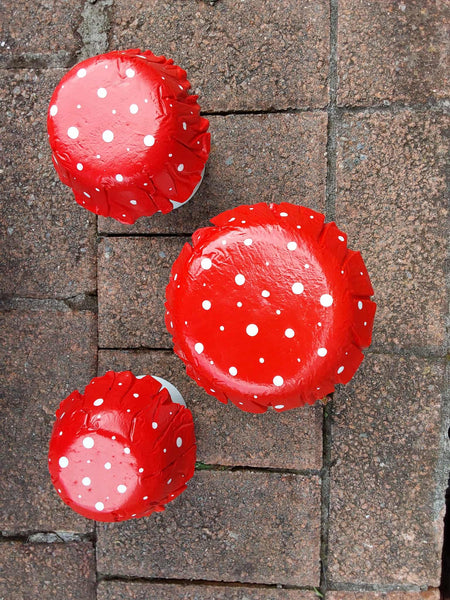 Set of 3 red concrete mushrooms.