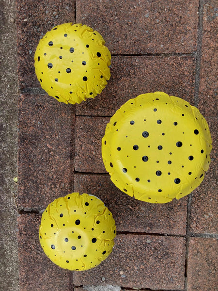 Set of 3 yellow concrete mushrooms.